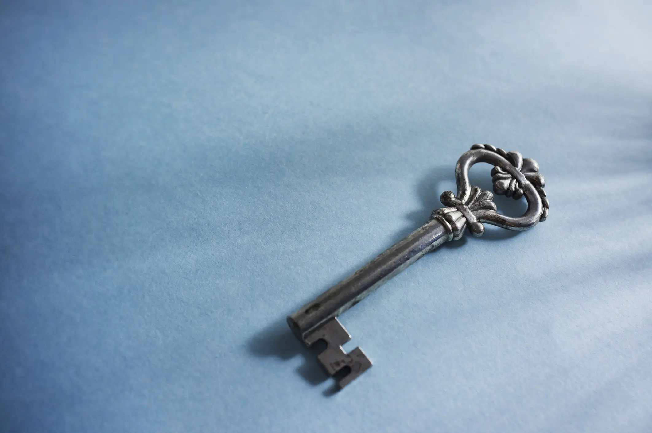 Vintage key on blue background with copy space